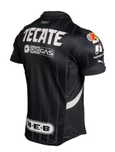 Back view of a black racing jersey with large Tecate logo, vertical stripes, and sponsor patches (Oxogas, H-E-B) on the lower back and sleeve area