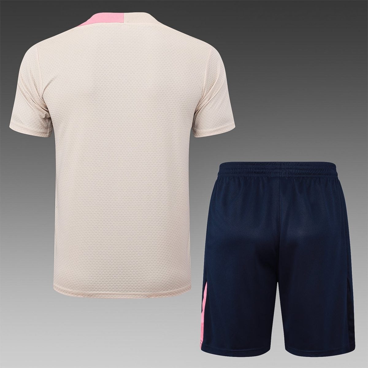 Back view of a beige textured athletic shirt paired with navy shorts featuring a pink stripe along the side.