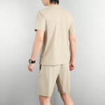 718e1a2f | UAE SPORT STORE Man wearing a beige short-sleeve T-shirt and matching shorts, viewed from behind.