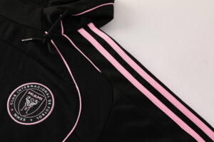 71f3ef37 | UAE SPORT STORE Black hoodie with pink side stripes and a circular Miami club emblem on the chest area.