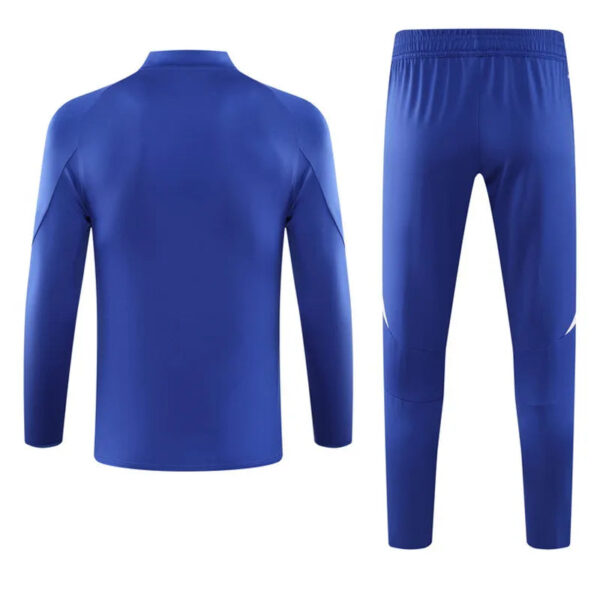 Blue athletic tracksuit set (long-sleeve top and tapered pants) shown from the back, solid royal blue with subtle paneling details at the shoulders and knees.