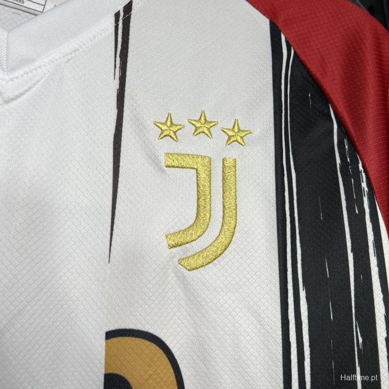 72cb88ba199ecd75 | UAE SPORT STORE Close-up of a Juventus football jersey showing the gold three-star crest and stylized J logo on white fabric.