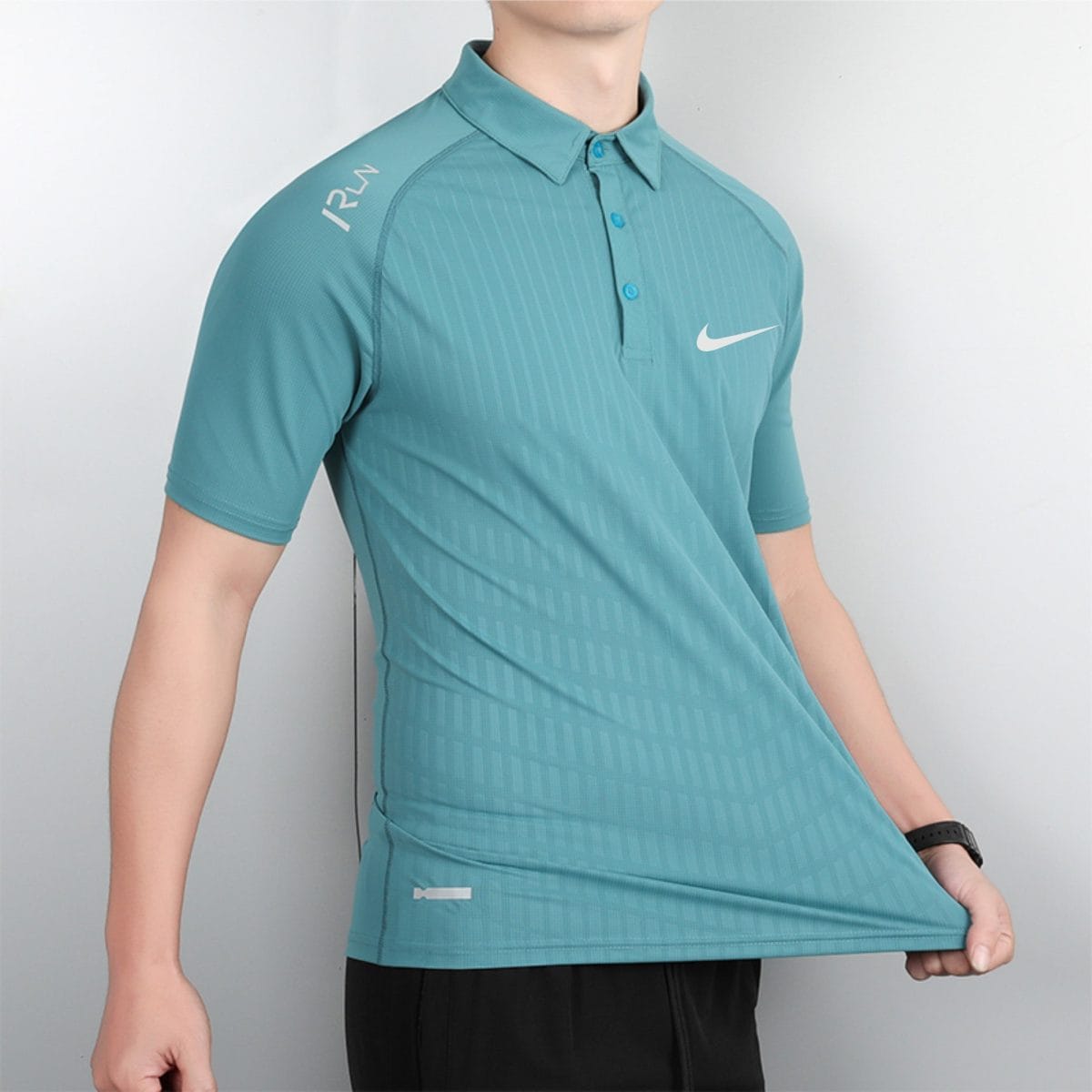 Person wearing a teal Nike polo shirt with faint vertical stripes, shown from the torso up against a neutral background, logo visible on chest.