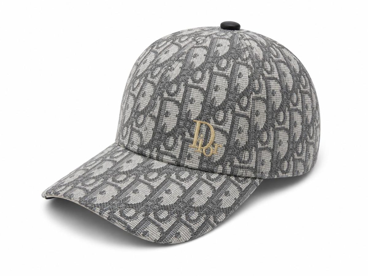 Grey Dior baseball cap with a repeating monogram pattern and a small gold 'Dior' emblem on the front.