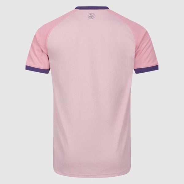 Back view of a light pink short-sleeve shirt with purple collar and sleeve cuffs; small circular logo near the neck.
