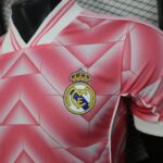 730e4a89-f7c6-4378-967c-a01473793f93 | UAE SPORT STORE Pink Real Madrid football jersey with a geometric diamond pattern and the club crest on the chest.
