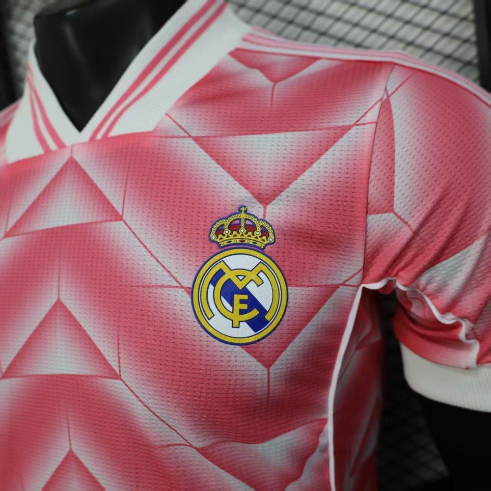 730e4a89-f7c6-4378-967c-a01473793f93 | UAE SPORT STORE Pink Real Madrid football jersey with a geometric diamond pattern and the club crest on the chest.