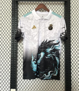 White Real Madrid jersey on a hanger with teal shoulder accents, Adidas logo, and a bold black/teal dragon graphic on the front.