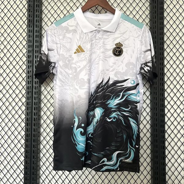 White Real Madrid jersey on a hanger with teal shoulder accents, Adidas logo, and a bold black/teal dragon graphic on the front.