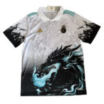 Real Madrid polo jersey with a bold black dragon graphic across the front and teal accents on the shoulders and collar.