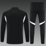 Black athletic tracksuit (jacket and pants) with white curved stripes on the sleeves and legs, set against a gray gradient background.