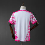 741ca0a6 | UAE SPORT STORE Back view of a white T-shirt with bright pink tribal-pattern trim along the sides and sleeves, displayed on a dress form.