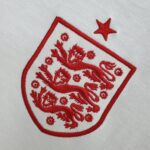 74a2614f_468deeca-8bd6-4b16-8889-6fabf89c3309 | UAE SPORT STORE Close-up of red embroidery on white fabric, showing a decorative border and floral motifs.
