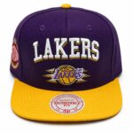 Purple Lakers cap with a yellow brim and embroidered 'LAKERS' on the front