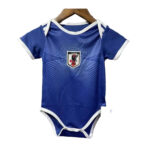 Blue baby onesie styled like a soccer jersey with white trim and a Japan crest on the chest, hanging on a wooden hanger