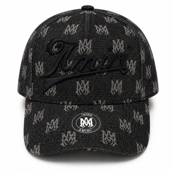 Black denim baseball cap with a repeated light logo pattern and a large embroidered cursive 'Amiri' on the front; round metal sticker on the brim.