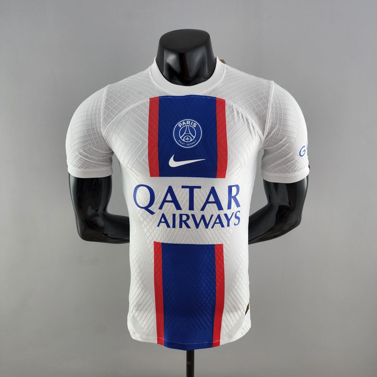 Mannequin wearing a white PSG football jersey with blue and red vertical stripe and Paris crest, Qatar Airways sponsor text visible.