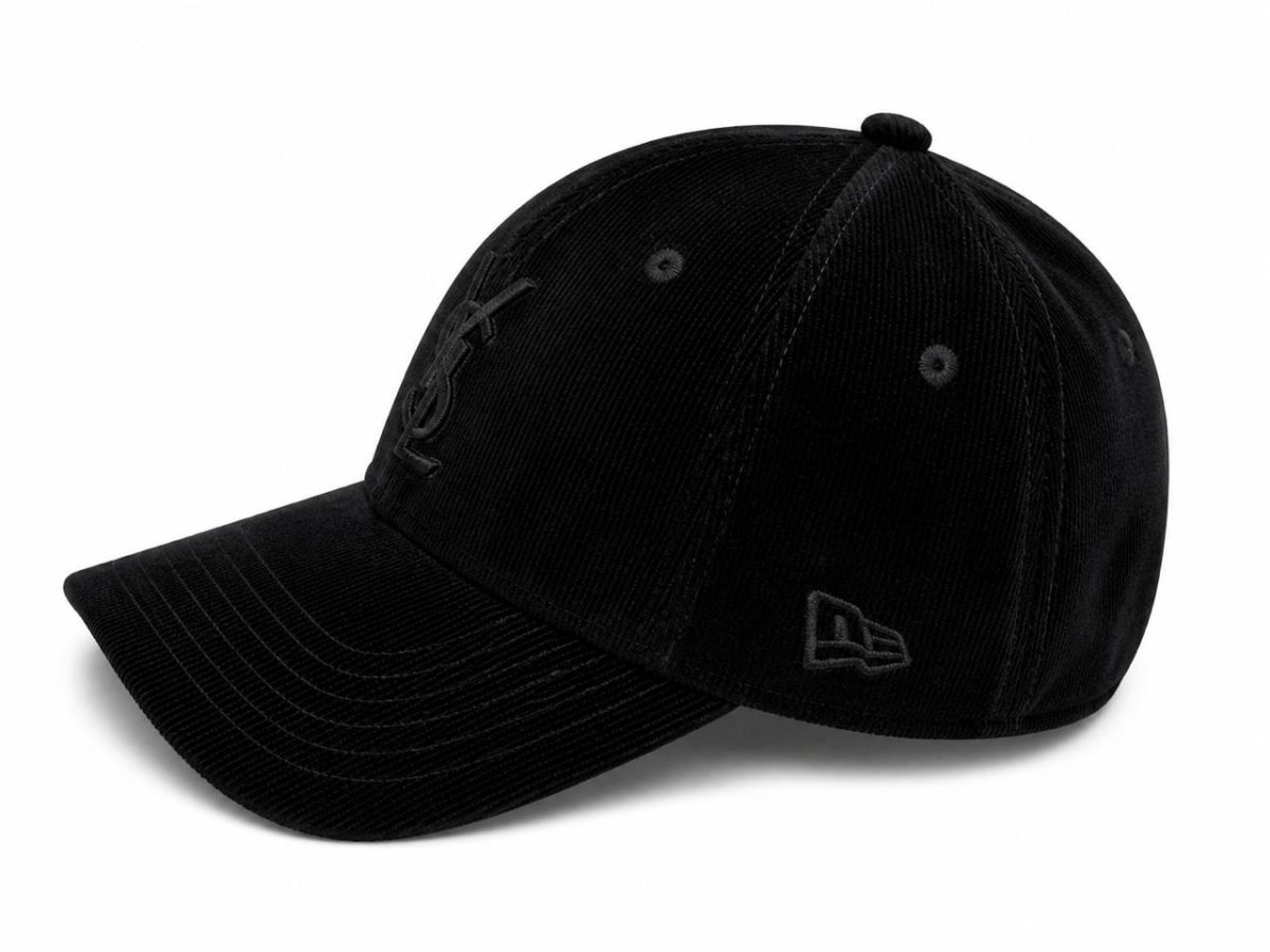Black corduroy baseball cap with curved brim, featuring embroidered branding on the front and a logo on the side.