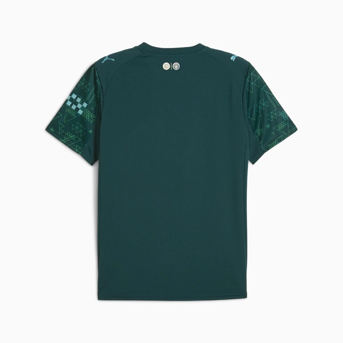 Teal athletic shirt with geometric pattern on sleeves, viewed from back. Small circular badges near collar.
