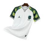 White Brazil national soccer jersey on a hanger, with green palm-pattern sleeves and team crest on the chest.