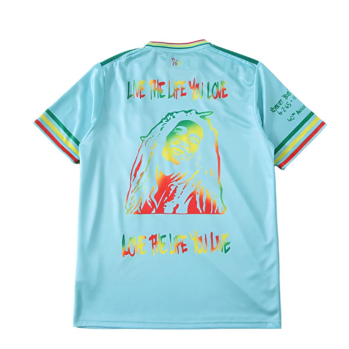 76ceeaa1_720x_90dadb53-6bf2-4ef0-87d7-50f58f013c26 | UAE SPORT STORE Back of a turquoise jersey with rainbow text 'LIVE THE LIFE YOU LOVE' and a large multicolor silhouette graphic on the back.