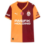 Football jersey in orange and maroon split color design, featuring Galatasaray crest and the Pasifik Holding sponsor on the front, with Puma logos on chest and sleeves.
