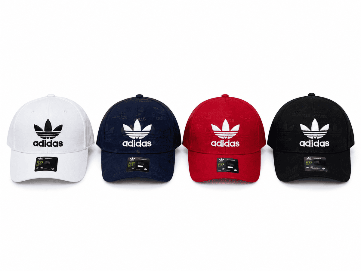 Row of four Adidas baseball caps in white, navy, red, and black with the white trefoil logo on the front.
