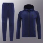 Blue Nike tracksuit pants and matching hoodie displayed on a gray backdrop.