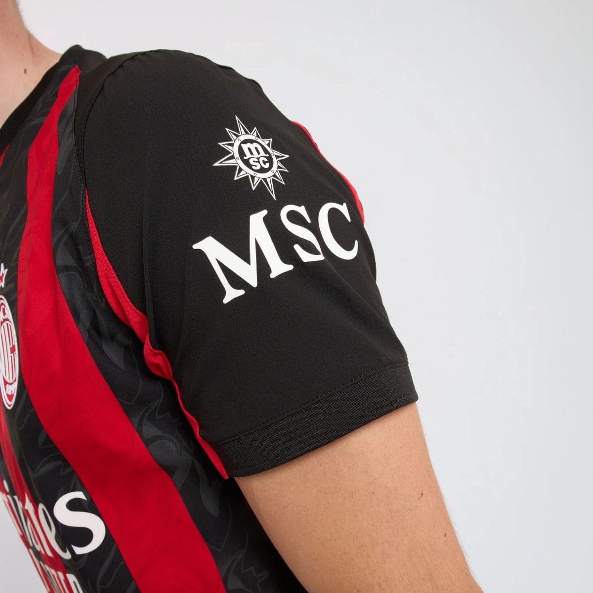 Black jacket sleeve with a red stripe and a white MSC logo on the chest/shoulder area, close-up view.
