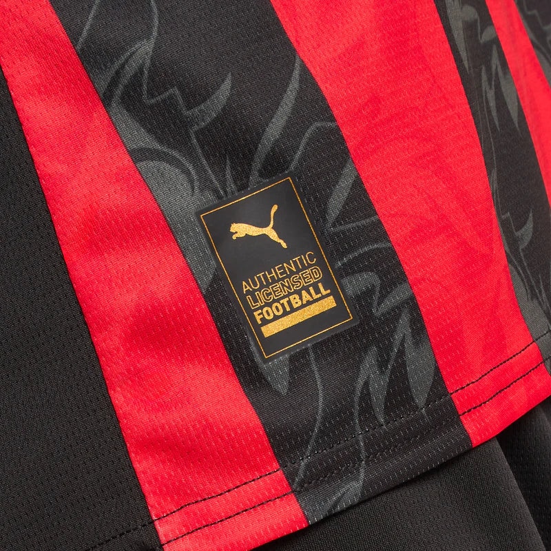 779962-A81_09_800x_450bb605-7da1-4227-bfda-fc61f0141f6b | UAE SPORT STORE Close-up of a red and black striped football jersey with a gold badge reading 'Authentic Licensed Football' and the Puma logo nearby.