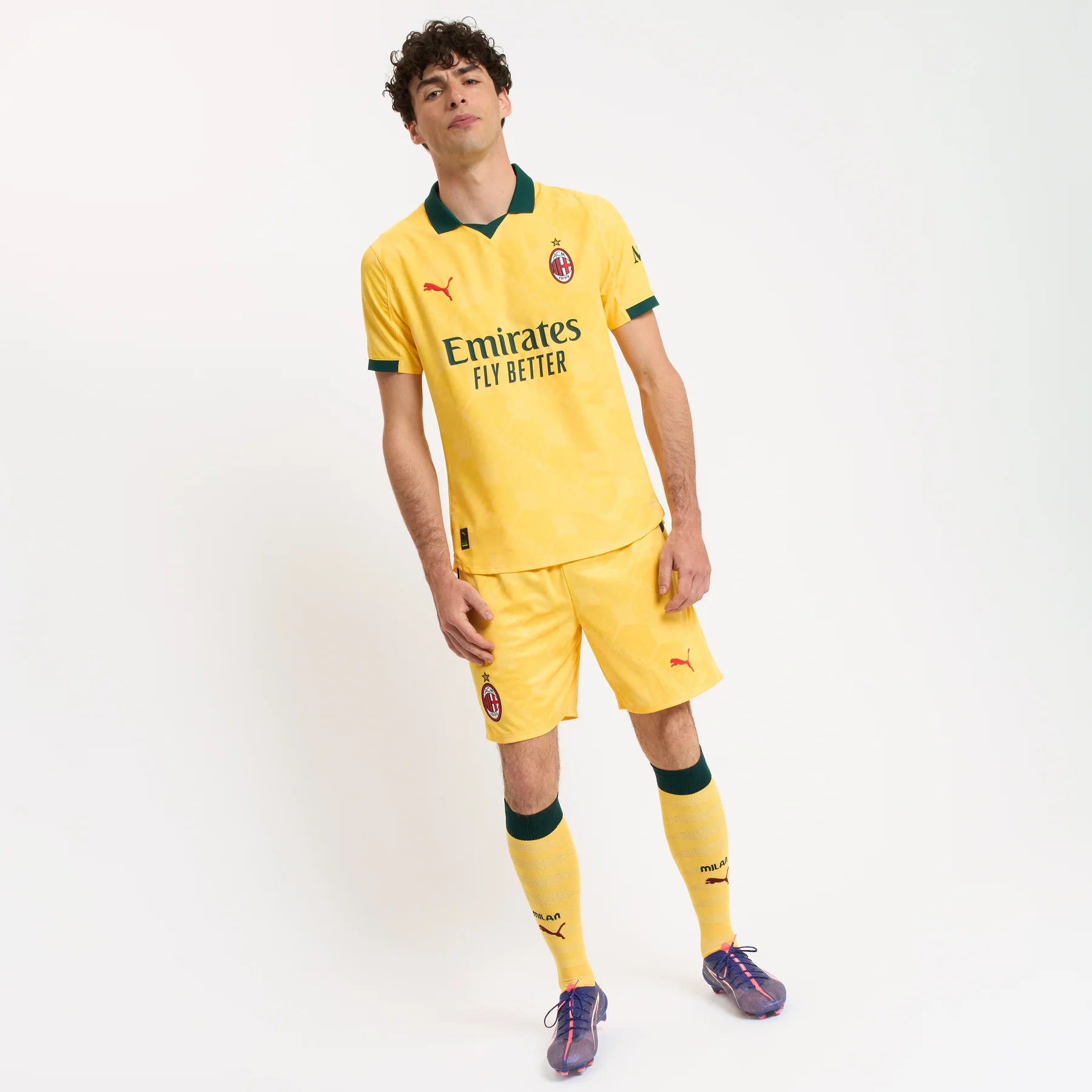 779978-C22_04_1800x1800_1f780201-cdc2-4186-b17f-7f4636e665d2 | UAE SPORT STORE Male soccer player wearing a yellow AC Milan kit with crest, standing against a white studio backdrop, sponsor text visible.