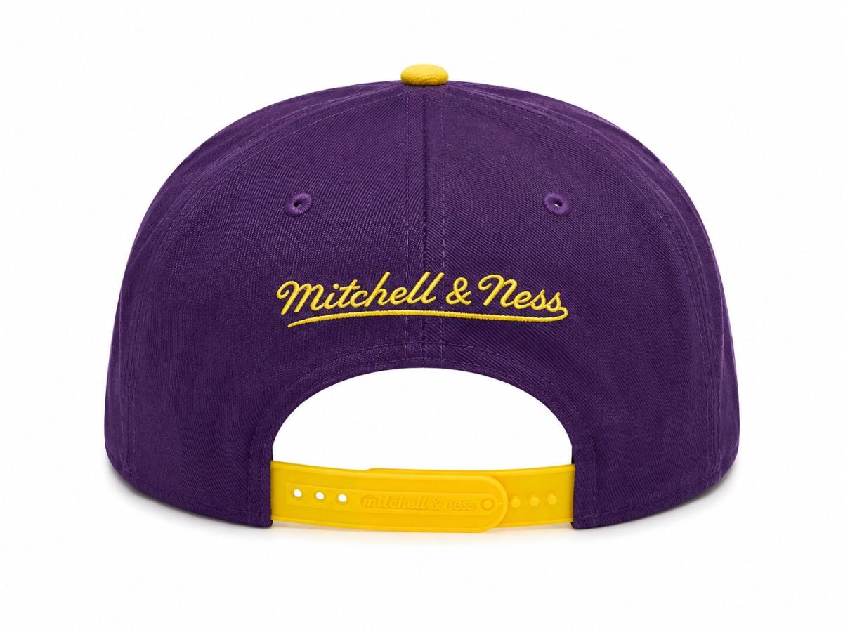 Purple Mitchell & Ness cap viewed from the back with a yellow adjustable strap and embroidered yellow script logo across the crown.