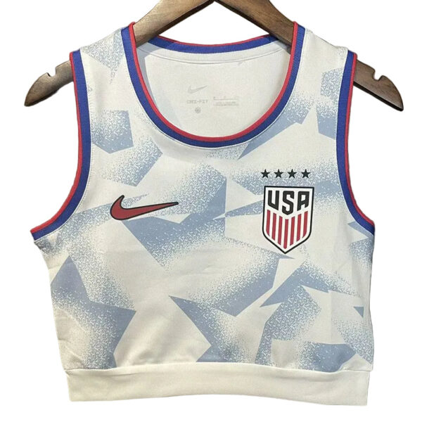 White USA basketball jersey with blue geometric pattern, Nike swoosh, and team crest on the chest, hanging on a wooden hanger.