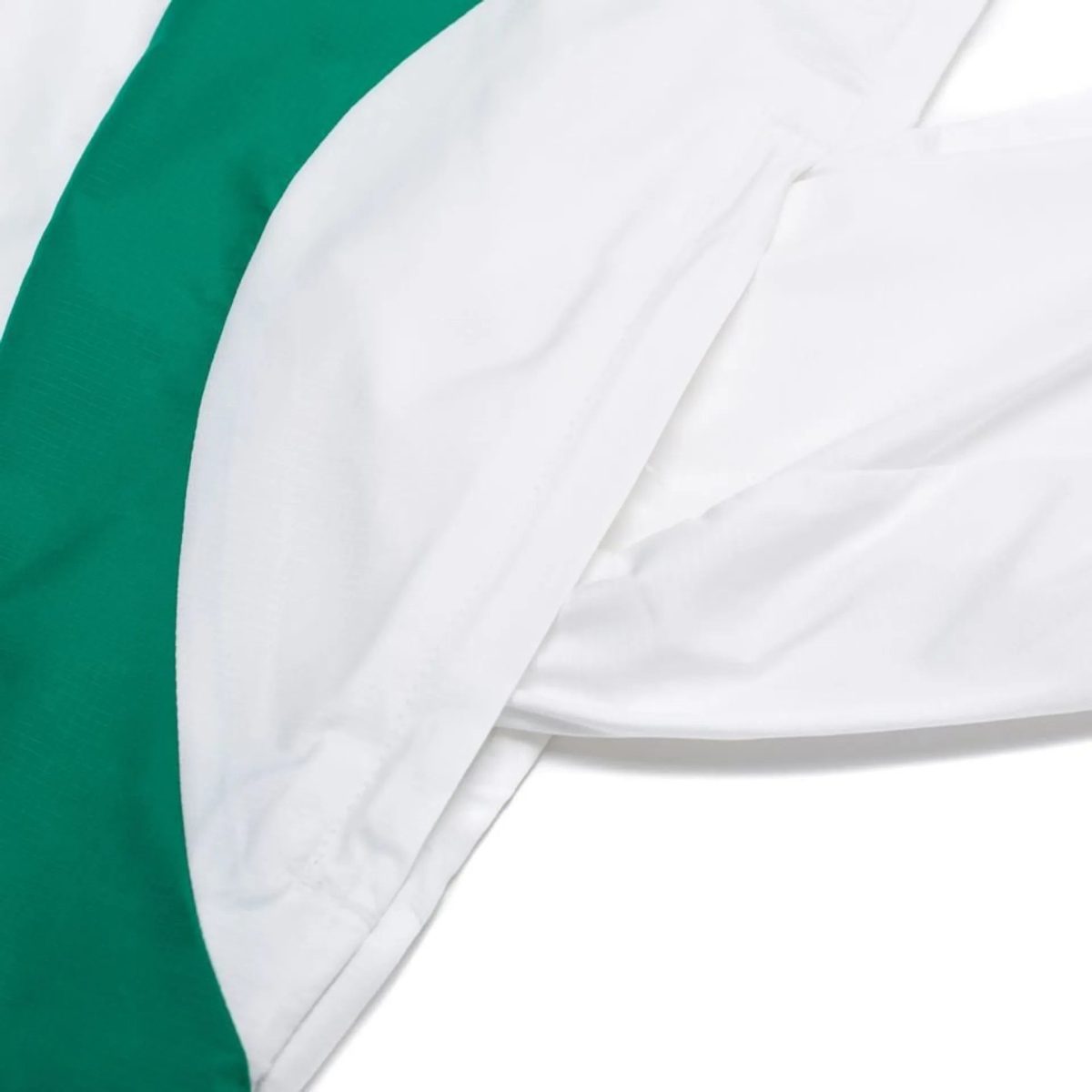 Close-up of white wrinkled fabric with a bold green diagonal stripe along the left edge