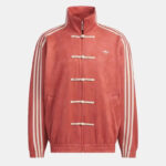 Red Adidas track jacket with white stripes along the sleeves, stand collar, and toggle closures down the front; small Trefoil logo on the left chest.
