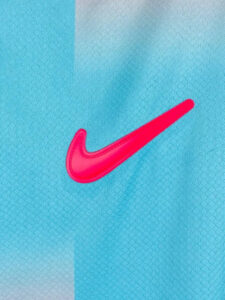 Bright pink Nike swoosh logo on blue fabric.