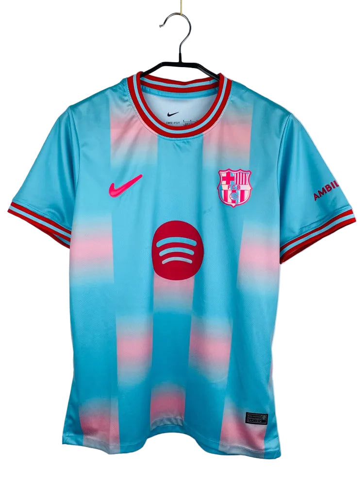 7984005461 FC Barcelona jersey on a hanger: light blue with pink gradient, with Nike swoosh, Barça crest, and Spotify sponsor logo.