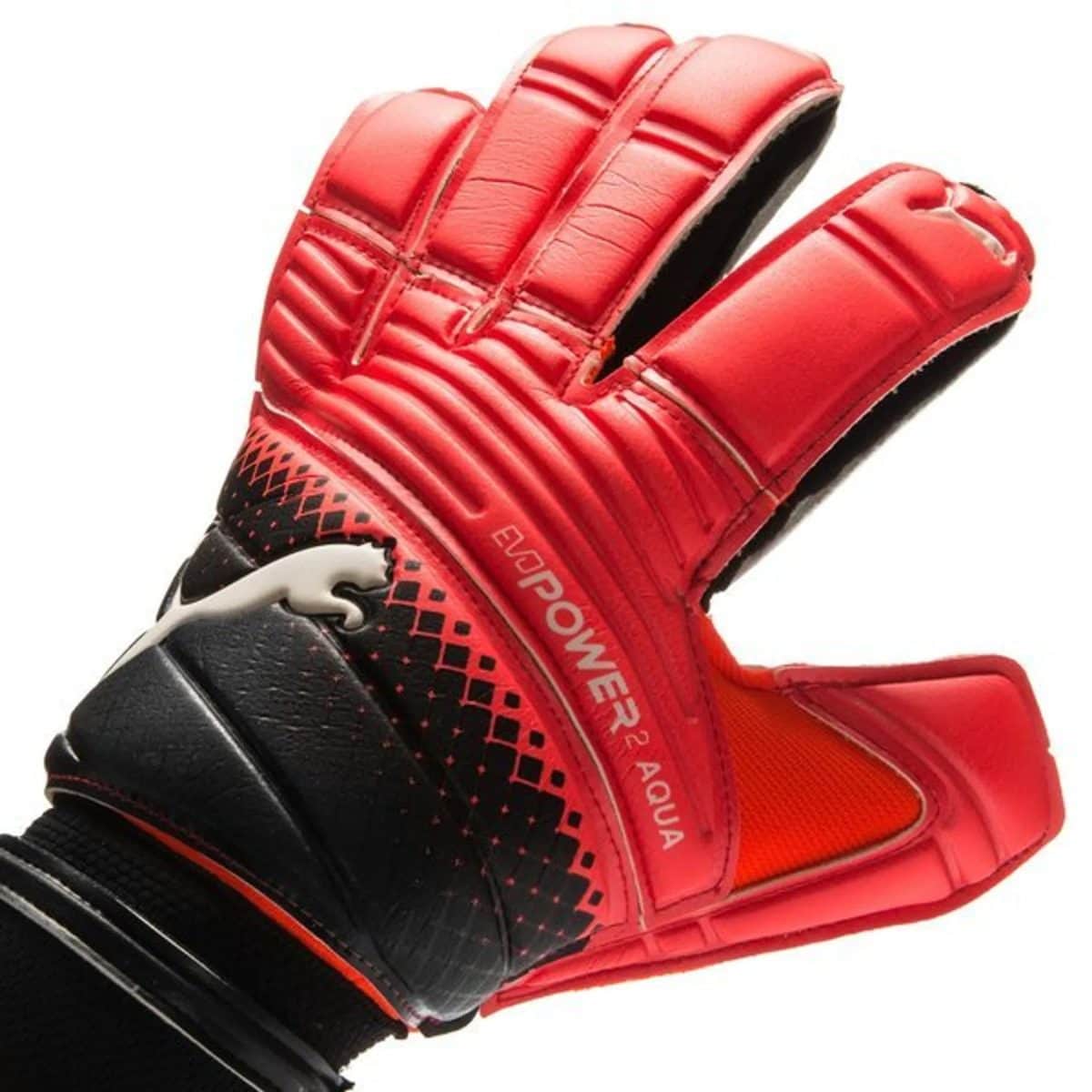 Close-up of a red goalkeeping glove with padded fingers and black palm on a white background