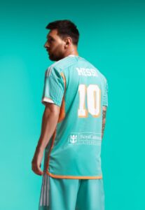 Soccer player wearing a teal Messi jersey viewed from behind, number 10, with Royal Caribbean sponsorship on the back.