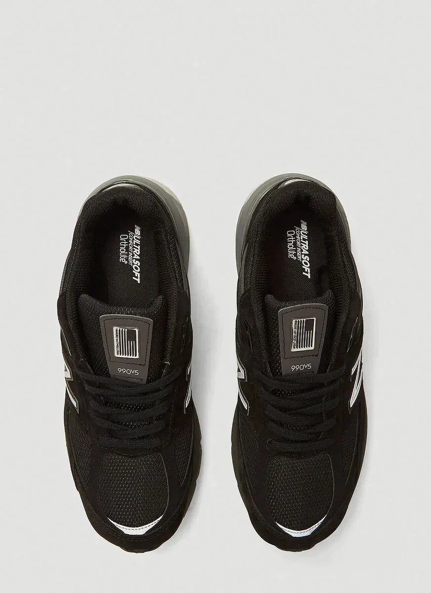 7a066a8dcc0bf7481565fa732351c61f_e5249ba9-ac24-4598-83d1-87416a295018 | UAE SPORT STORE Two black athletic sneakers viewed from above, showing laces and white striped accents on the sides.