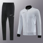 Nike black track pants with white swoosh, beside a white zip-up athletic jacket with black collar and cuffs.