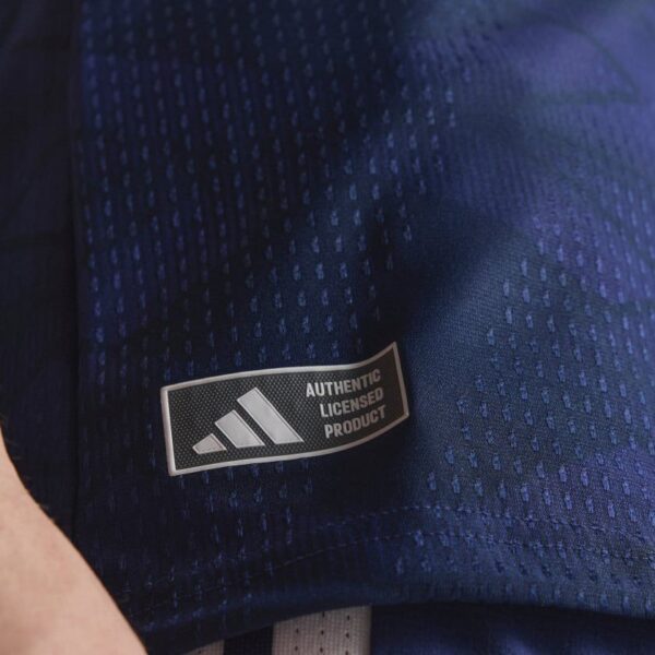 Close-up of a blue fabric tag reading Authentic Licensed Product on a navy athletic material.