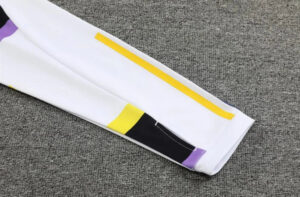 White color-block sleeve with a yellow stripe and purple/black accents on a gray carpet surface.