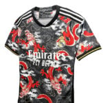 7ae775a0-d619-4915-990a-1ffbc31c4599 | UAE SPORT STORE Real Madrid soccer jersey with red dragon pattern, featuring Emirates Fly Better text and club crest on a black background with white stripes on the shoulders.