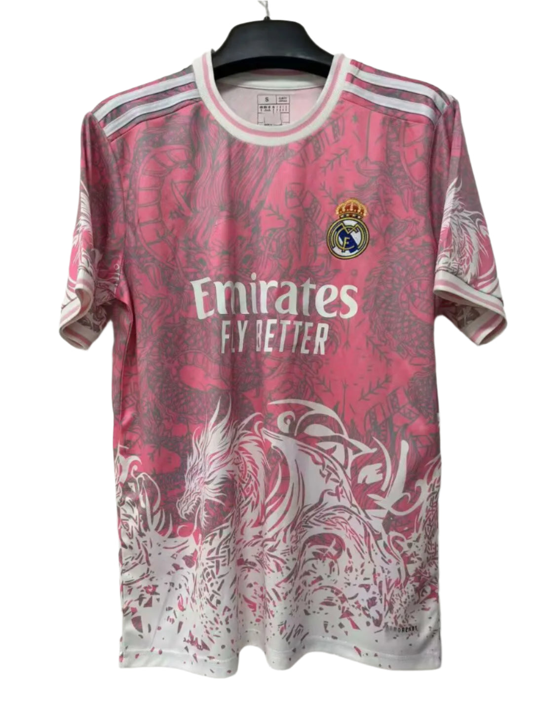 7b39ed07-f275-4dc9-835b-692934bcccd7 Pink Real Madrid football jersey on a hanger, with the Emirates Fly Better sponsor and club crest visible.