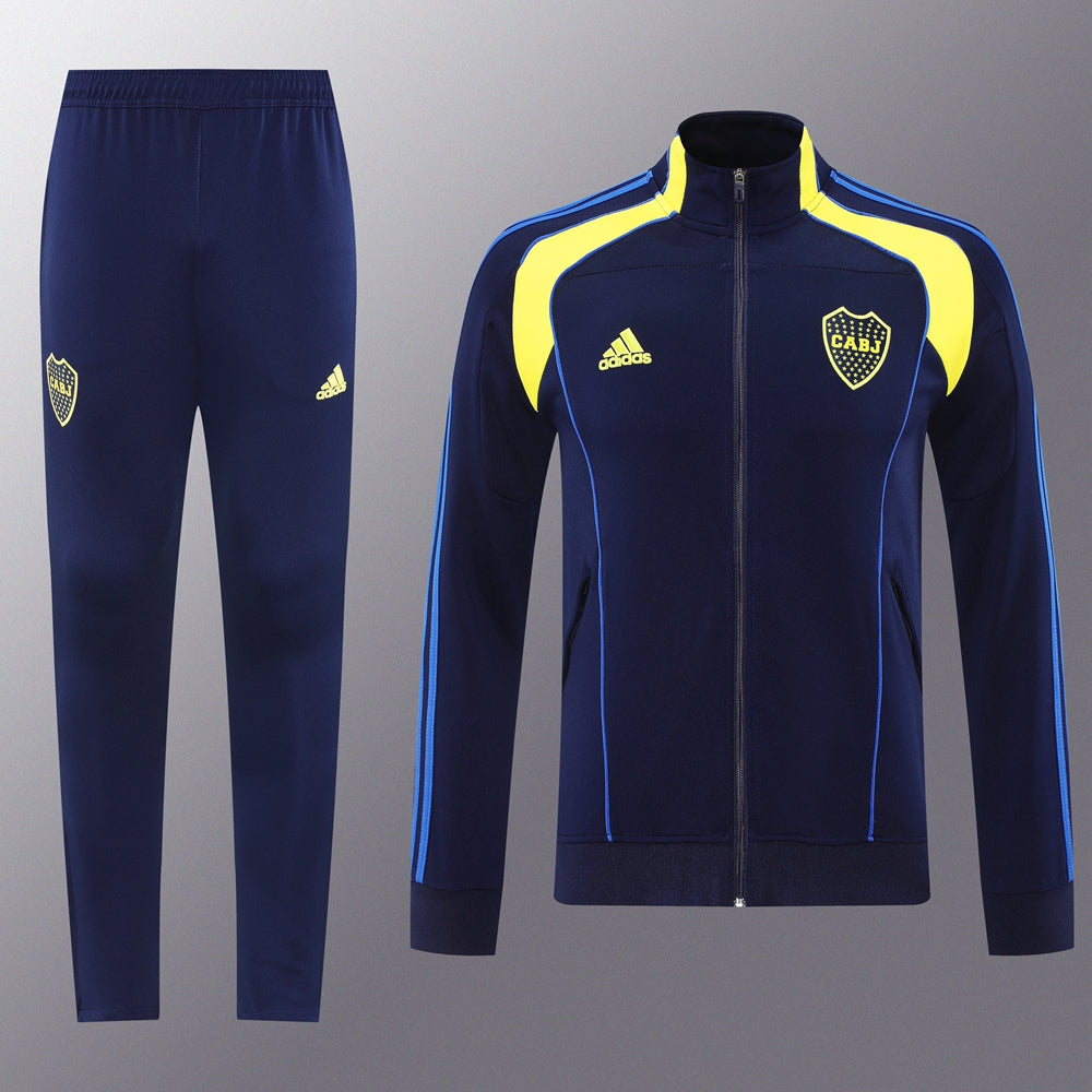 7bd8f9e3 | UAE SPORT STORE Navy blue Adidas tracksuit with yellow accents: zip-up jacket with crest and pants featuring small crest, both with blue piping and stripes.