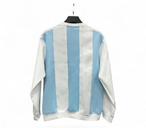 Back view of a light blue and white vertical striped jacket hanging on a black hanger.