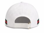 White Gucci cap shown from the back with an adjustable strap and gold ring, featuring an embossed Gucci monogram pattern across the fabric.