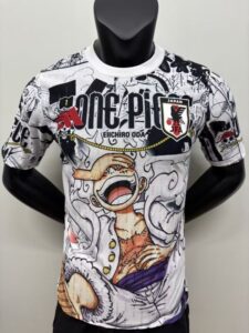 White graphic T-shirt featuring a large anime-style pirate character yelling, with the 'ONE PIECE' logo and a Japan JFA badge.