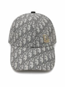 Grey Dior monogram cap with gold 'Dior' emblem on the front right panel, six-panel baseball hat style.